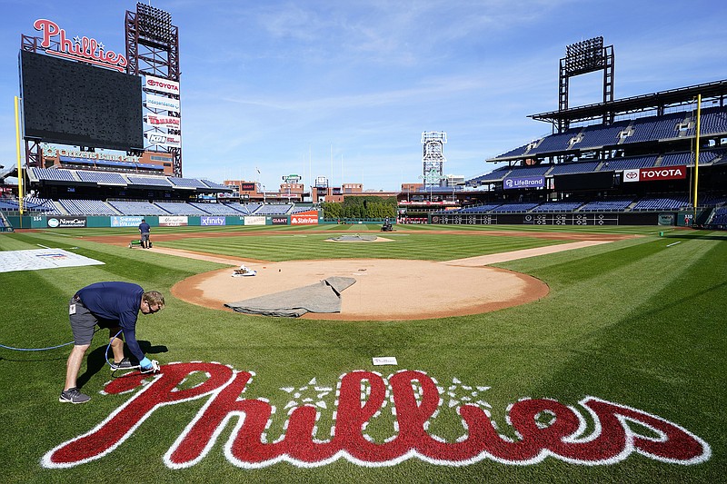 AP photo by Matt Rourke / Citizens Bank Park grounds crew member Jeremy Wilt paints the playing field Wednesday in preparation for Game 3 of the NL Division Series between the Atlanta Braves and the host Philadelphia Phillies on Friday. The best-of-five series is tied 1-1.