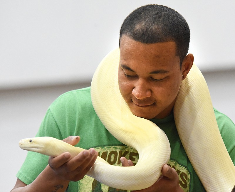 Staff photo by Matt Hamilton / Nathan Adams of Chickamuaga holds a white Burmese python at a booth during Repticon at the Camp Jordan Arena in East Ridge on Aug. 28, 2022. Repticon features a variety of exotic reptiles to look over and purchase, as well as spiders, scorpions, exotic cats, insects and other alternative pets.