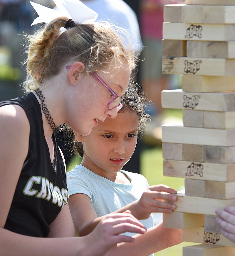 Staff File Photo by Matt Hamilton / Kaley Hill, 11, of Ringgold, Ga., left, and Eula May Pilkington, 8, of Chattanooga, play a giant version of Jenga at Camp Jordan during the East Ridge centennial celebration on Sept. 25, 2021. The success of that event led city officials to launch an annual fall festival with similar activities for families to enjoy.