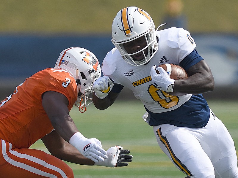 Staff photo by Matt Hamilton / UTC's Ailym Ford carries the ball as Mercer's Isaac Dowling delivers a hit during last Saturday's game at Finley Stadium. Ford rushed for 123 yards against the Bears, surpassing the 3,000 mark for his Mocs career and moving into fifth place on UTC's list of all-time rushing leaders.