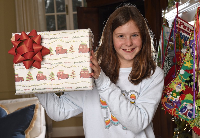 Staff File Photo by Matt Hamilton /  Cora Stowe, 11, shows off her winning design in the 2021 Lin C. Parker Wrapping Paper Design Contest at home on Signal Mountain.