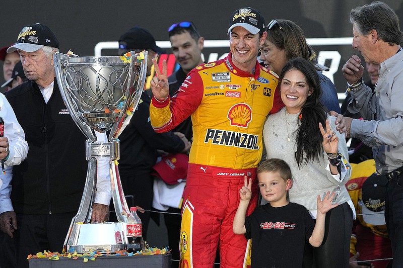 AP photo by Rick Scuteri / Team Penske driver Joey Logano and his family hold up two fingers to indicate his second NASCAR Cup Series title as they celebrate after after he won Sunday's season finale at Phoenix Raceway.