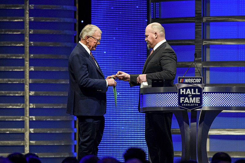 AP photo by Mike McCarn/ Coy Gibbs, right, presents a NASCAR Hall of Fame ring to his father, Joe Gibbs, during his induction ceremony on Jan. 31, 2020, in Charlotte, N.C.
