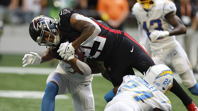 Atlanta Falcons running back Tyler Allgeier (25) dives for extra yardage as he is tackled by Los Angeles Chargers safety Nasir Adderley (24) during the second half of an NFL football game, Sunday, Nov. 6, 2022, in Atlanta. (AP Photo/Butch Dill)