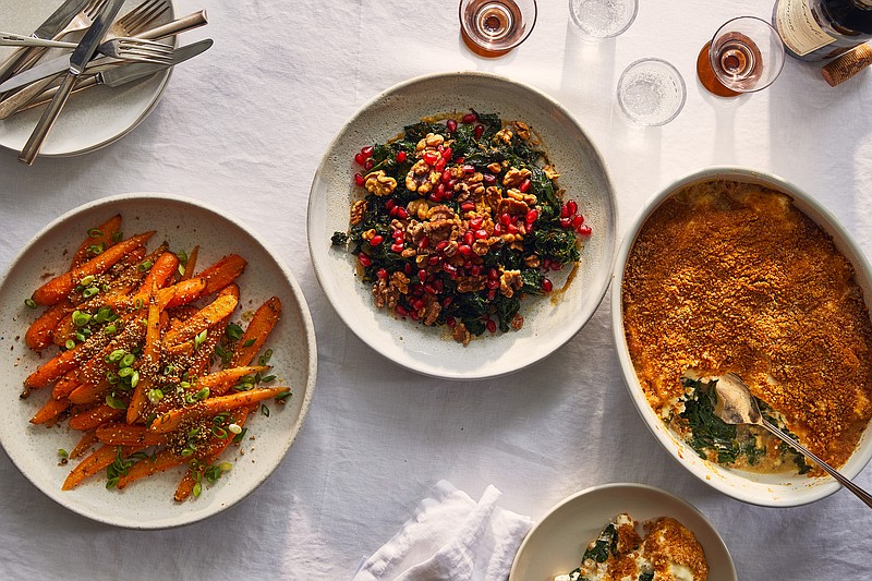 Bring hearty flavor to the Thanksgiving table with, from left, glazed carrots with miso and sesame; warm kale salad with walnuts and pomegranate; and creamy chard with ricotta, parmesan and bread crumbs. / Christopher Simpson/The New York Times
