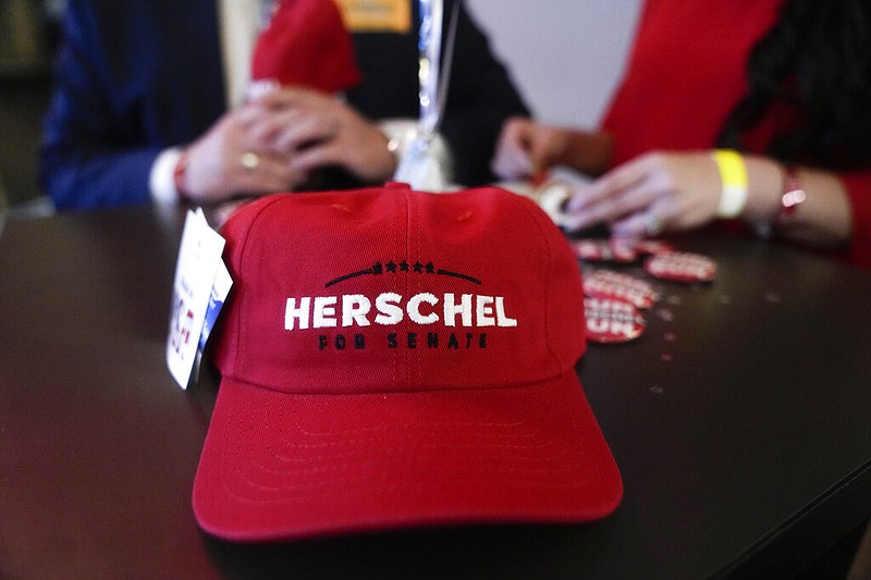 AP Photo / Brynn Anderson / A Herschel Walker hat sits on a table during an election night watch party on Tuesday in Smyrna, Ga.