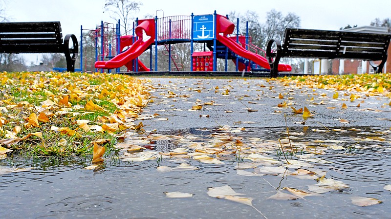 Staff Photo by Robin Rudd /  Ginkgo leaves are submerged in a puddle in a sidewalk at Jack Benson Heritage Park in East Brainerd, while the playground is empty, on Nov. 11, 2022.  Meteorologists say the  remnants of Hurricane Nicole helped but won't quite bust the drought that has gripped the Chattanooga area over the past weeks.
