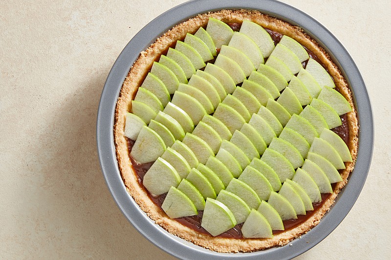 Arrange slices of Granny Smith apples atop the caramel filling for this Caramel Apple Pie. / Sang An/The New York Times
