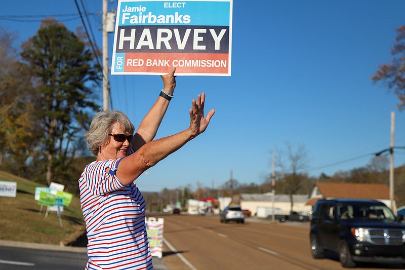 Staff Photo By Olivia Ross  / Deirdre Hamill waves at passing cars as she stumps for votes for Red Bank Commission candidate Jamie Fairbanks Harvey outside Calvary Baptist Church on Election Day earlier this month.