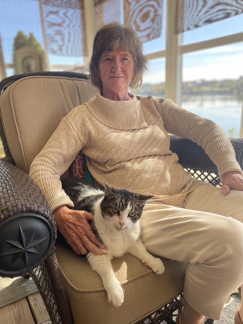 Staff Photo by Mark Kennedy / Cherie Martinez, a retired United Airlines pilot, sits Nov. 9 in her sunroom in Heritage Landing with one of her four adopted cats. Martinez spent 31 years at United Airlines, including 21 as captain.