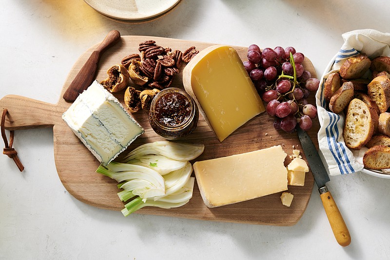 A few cheeses, some fruits and nuts, and bread or crackers are all you need to build an artfully arranged cheese board. / David Malosh/The New York Times