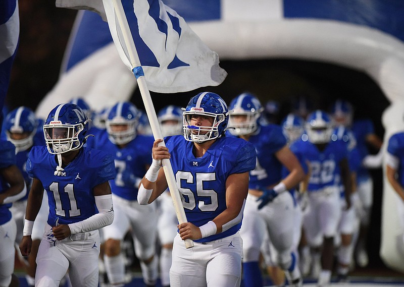 Staff photo by Matt Hamilton / McCallie football player Ridley McDonald carries a flag as he takes the field with his teammates before a Nov. 4 home game against St. Benedict in the opening round of the TSSAA Division II-AAA playoffs.