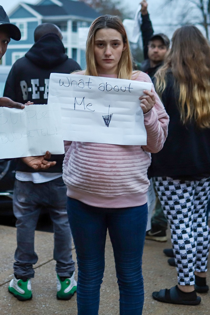 Staff file photo by Olivia Ross  / Ruby Williamson, a Budgetel resident who is 30 weeks pregnant, holds a sign outside of East Ridge City Hall in the hours before the hotel was closed earlier this month.