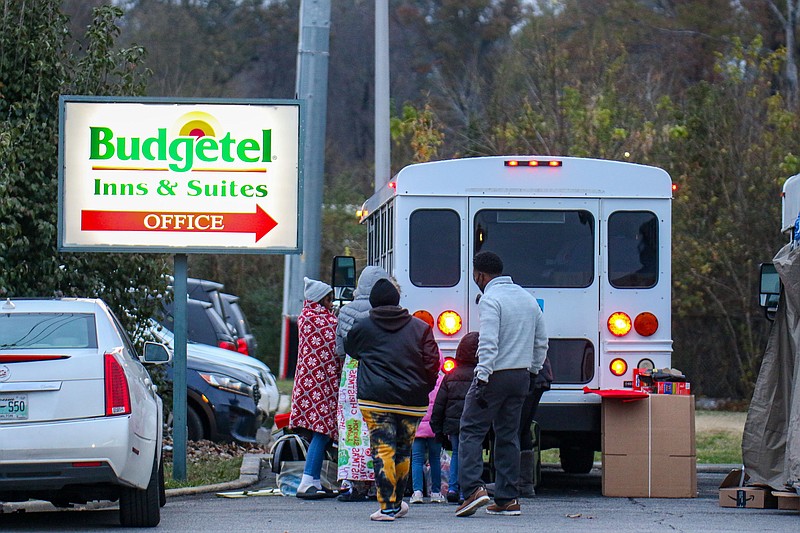 Staff Photo by Olivia Ross  / Residents wait outside Nov. 16 at the Budgetel Inn. After being told early that morning they had just few hours to leave the building, many residents begin packing their belongings. The building was shut down due to high crime.