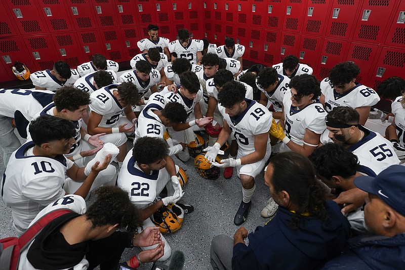 Crestwood High School football player Adam Berry (19) leads a muslim prayer before a game in Melvindale, Mich., Friday, Sept. 23, 2022. (AP Photo/Paul Sancya)
