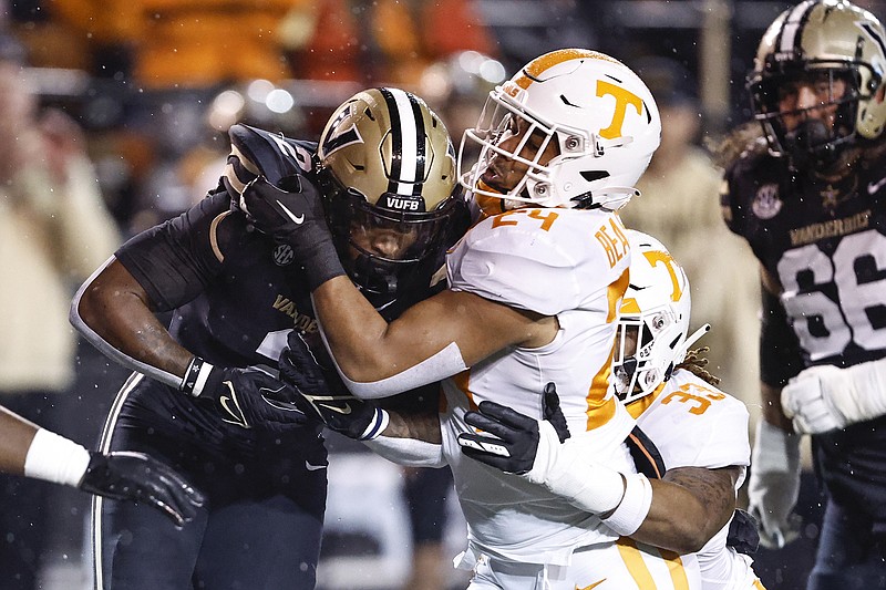AP photo by Wade Payne / Vanderbilt running back Ray Davis is tackled by Tennessee linebackers Aaron Beasley (24), and Jeremy Banks (33) during the first half of Saturday night's game in Nashville.
