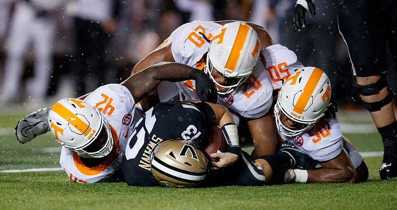 Tennessee Athletics photo / Tennessee defensive linemen Tyre West (42), Bryson Eason (20) and Jordan Phillips (50) converge on a stop of Vanderbilt quarterback AJ Swann during Saturday night’s 56-0 win by the Volunteers.