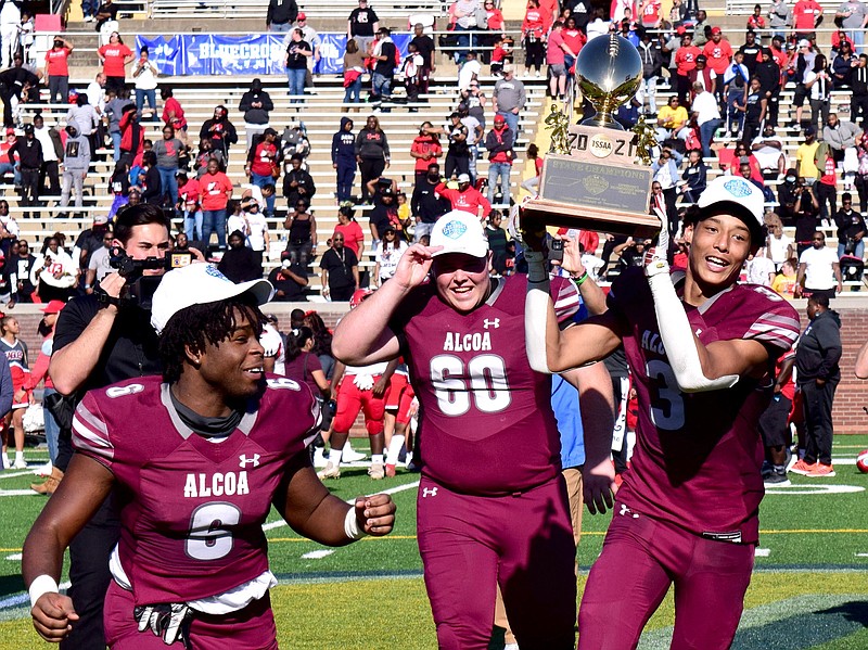 Staff File Photo by Robin Rudd / Alcoa's Major Newman, right, takes off with the championship trophy as teammates Itty Salter, left, and McCoy Mothershed follow. The Alcoa Tornadoes defeated the East Nashville Eagles 45-14 to win the TSSAA Division 1, Class 3A football championship in the BlueCross Bowl at Finley Stadium, on Dec. 3, 2021.