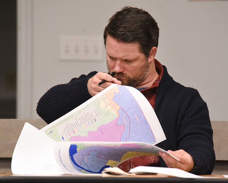 Staff Photo by Matt Hamilton / School board member Ben Connor looks over rezoning maps during a school board facilities meeting at the Hamilton County Schools Board of Education meeting room on Monday.