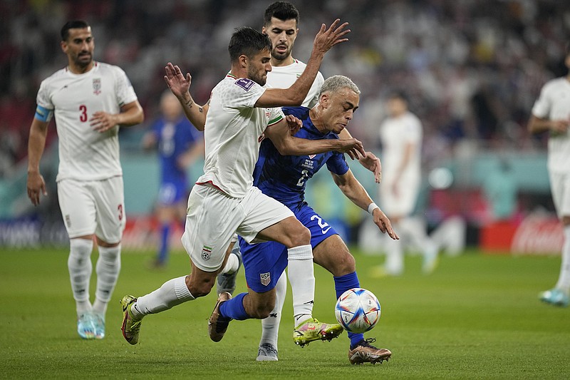 File photo/Ebrahim Noroozi/The Associated Press / Sergino Dest of the United States fights for the ball with Iran's Milad Mohammadi during the World Cup group B soccer match between Iran and the United States at the Al Thumama Stadium in Doha, Qatar, on Nov. 29, 2022.