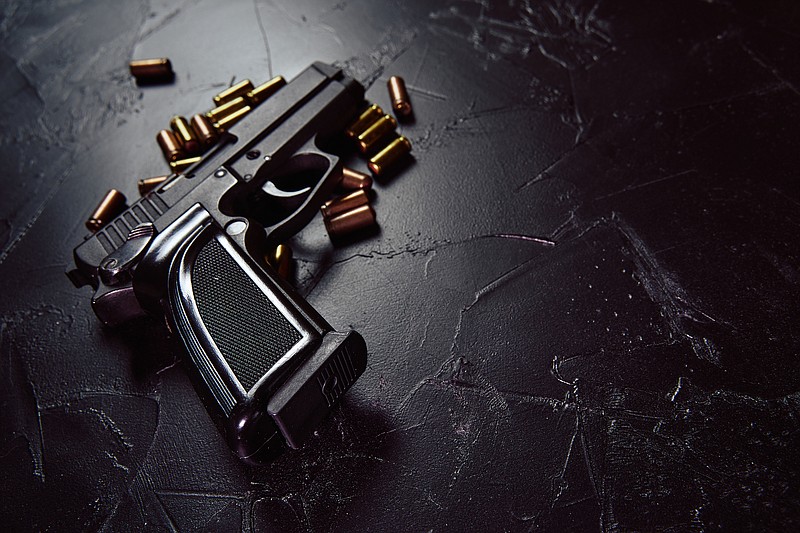 Handgun with bullets / Getty Images