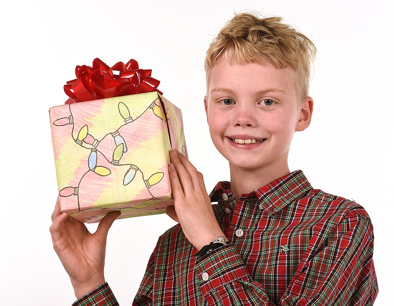 Staff Photo by Matt Hamilton / Cliff Algea, 10, with his gift wrap design at the Times Free Press on Dec. 7, 2022.