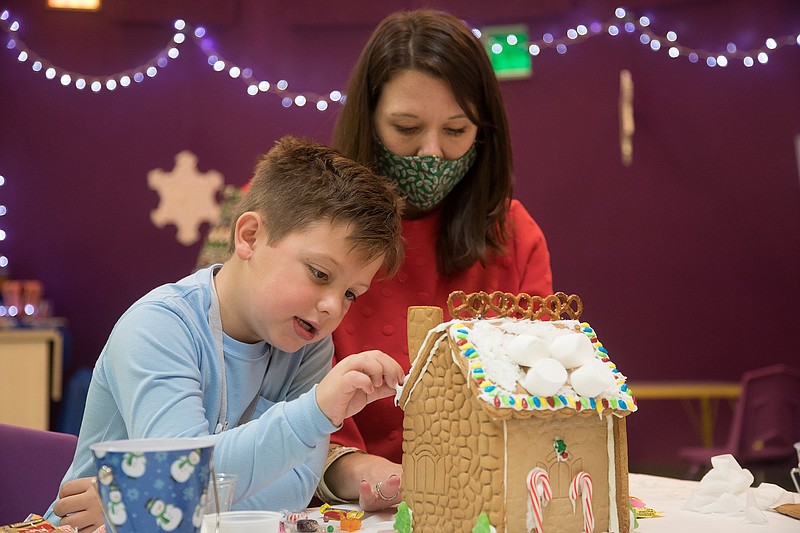 Staff file photo / Matthew DeWeese, 7, and his mother, Kristen, work on a gingerbread house during a Gingerbread House Workshop at the Creative Discovery Museum on Nov. 29, 2020. This year's workshops continue on select dates through Dec. 18.