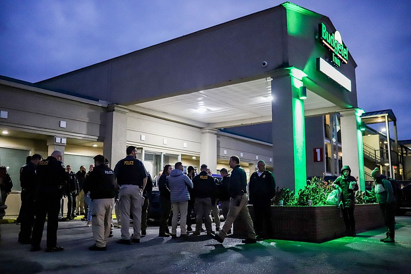 Staff Photo by Olivia Ross  / Guests and officers stand outside the Budgetel on Nov. 16. After being told to leave the motel, many guests of the extended-stay motel in East Ridge, begin packing their belongings that morning.