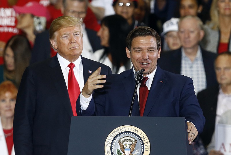 Then-President Donald Trump stands behind gubernatorial candidate Ron DeSantis at a rally in Pensacola, Fla., in 2018. (AP Photo/Butch Dill, File)