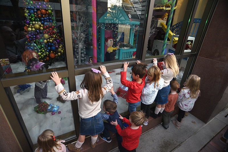 Staff Photo by Matt Hamilton / Children gather to look through the display windows during the annual reveal of the holiday windows at the EPB main office on Nov. 23. The free display, which features an interactive window, will be open through Jan. 6.