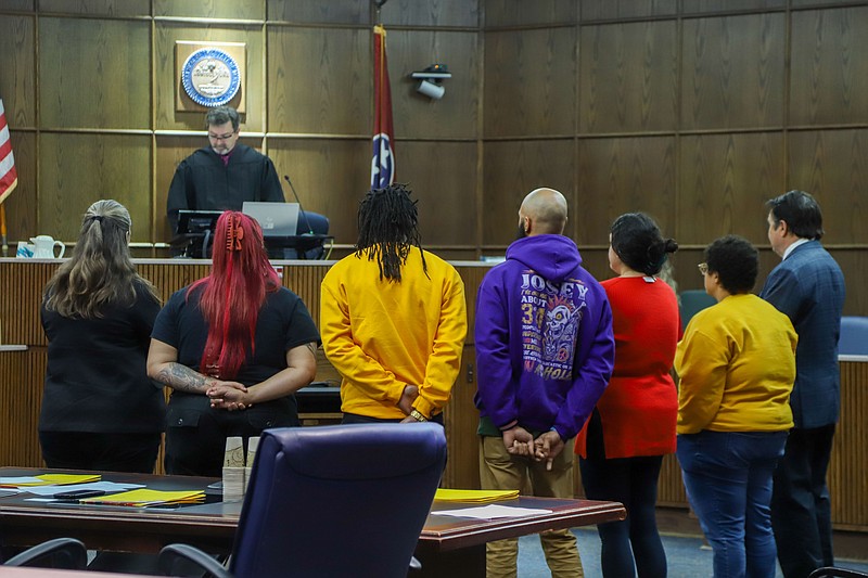 Staff photo by Olivia Ross  / Grason Harvey, Cameron Williams, Cedric Josey and Marie Mott stand with attorneys in front of Judge Boyd Patterson on December 15, 2022. Marie Mott appeared for a hearing on charges from 2020 protests.