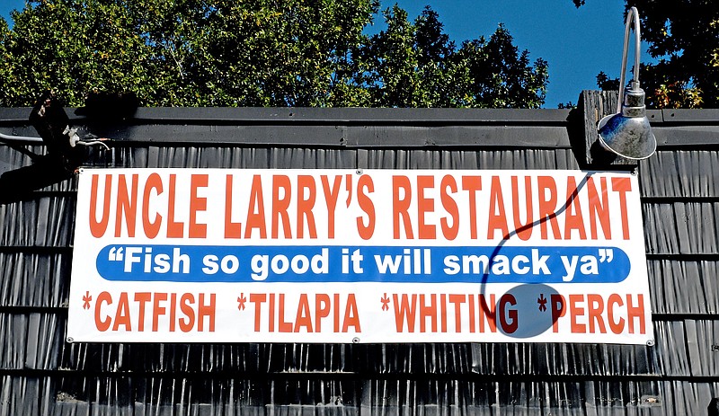 Staff Photo by Robin Rudd / A temporary banner displays Uncle Larry's slogan, atop the new location at 8701 East Brainerd Road on Oct. 6. Larry Torrence opened his fourth Uncle Larry's restaurant last weekend, and the location will offer beer.