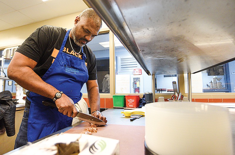 Staff Photo by Matt Hamilton / Chef Kenyatta Ashford chops sausage for a gumbo at Kitchen Incubator of Chattanooga.
