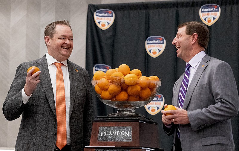 Tennessee Athletics photo by Andrew Ferguson / Tennessee football coach Josh Heupel, left, and Clemson counterpart Dabo Swinney share a laugh Thursday while standing beside the Orange Bowl championship trophy. The No. 6 Volunteers and No. 7 Tigers will collide inside Hard Rock Stadium on Friday night.