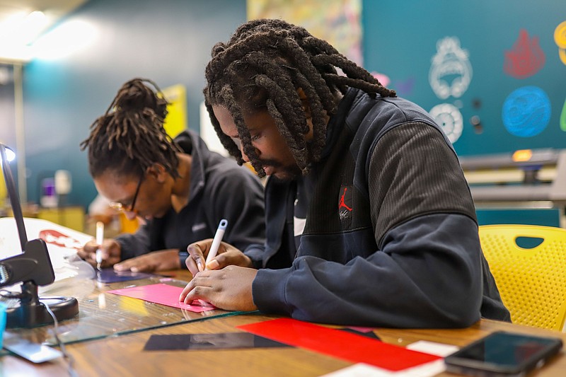 Staff photo by Olivia Ross  / Michael and Nikki Bryant peel off vinyl for their shirt designs on the fourth floor of Chattanooga Public Library's downtown branch on Friday.