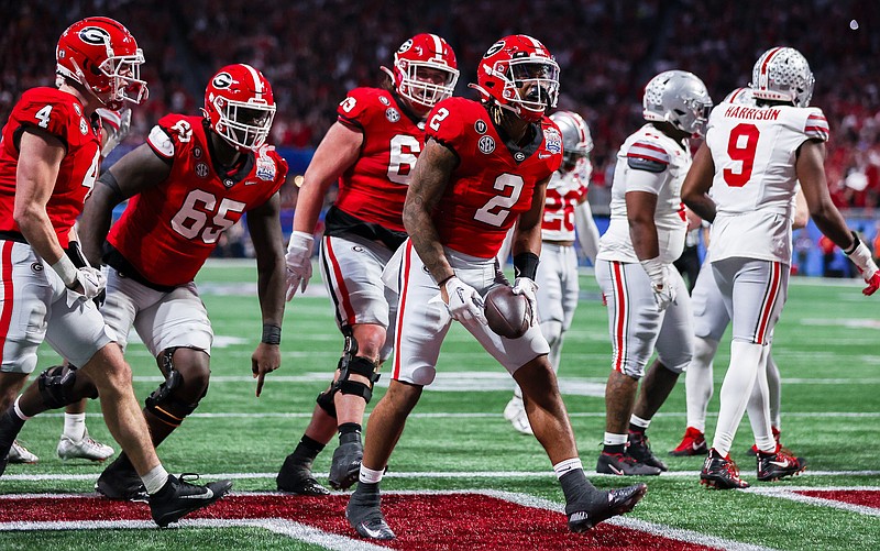 Georgia photo by Tony Walsh / Georgia running back Kendall Milton (2) celebrates a touchdown during last Saturday night’s 42-41 win over Ohio State at the 2022 Chick-fil-A Peach Bowl as tight end Oscar Delp (4) and offensive linemen Amarius Mims (65) and Tate Ratledge (69) prepare to join in. Milton, Delp, Mims and Ratledge all signed with the Bulldogs as top-100 national prospects.