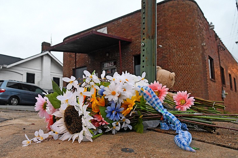 Staff Photo by Robin Rudd / A makeshift memorial sits at the base of a street sign outside Mary's Bar and Grill at 2125 McCallie Avenue, in Chattanooga on June 7.  Three people were killed and 14 others wounded and injured after a shooting in the early morning of June 5.