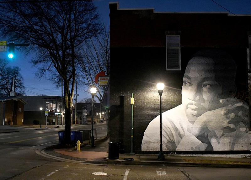 Staff Photo by Robin Rudd /  Dawn breaks in the eastern sky as a mural of Martin Luther King Jr. appears to look upon the empty street that bears his name. The artwork, located at the intersection of Marin Luther King Jr. Boulevard and Peeples Street, was painted by Chattanooga muralist Kevin Bate in 2012. It was inspired by a 1963 photo by Flip Schulke, who recorded much of King's civil rights work. Schulke took the photo just after King's "I Have a Dream" speech delivered in front of the Lincoln Memorial in Washington.