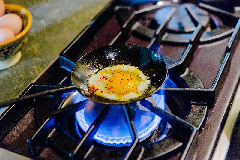 File photo/Alex Welsh/The New York Times / A gas stove is used to cook an egg in Berkeley, Calif., on March 13, 2018. Concerns raised by the nation’s top consumer watchdog about the health hazards posed by gas stoves have triggered a sharp rebuke from the oil and gas industry and its Republican allies, inserting a common kitchen appliance into the middle of partisan politics.