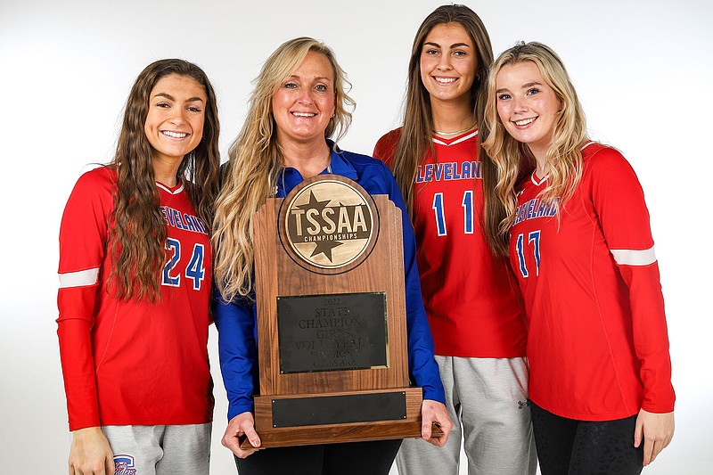 Staff photo by Olivia Ross / From left, Cleveland High School outside hitter Addison Hurst, volleyball coach Amy McGowan, outside hitter Lauren Hurst and setter Kinslee McGowan pose with the Lady Blue Raiders' TSSAA Class AAA state championship trophy from the 2022 season. Lauren is Gatorade's 2022-23 volleyball player of the year for Tennessee.