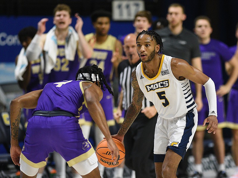 Staff photo by Matt Hamilton / UTC senior guard Jamal Johnson brings the ball across midcourt as Western Carolina's Tyler Harris defends during Wednesday's SoCon game at McKenzie Arena.