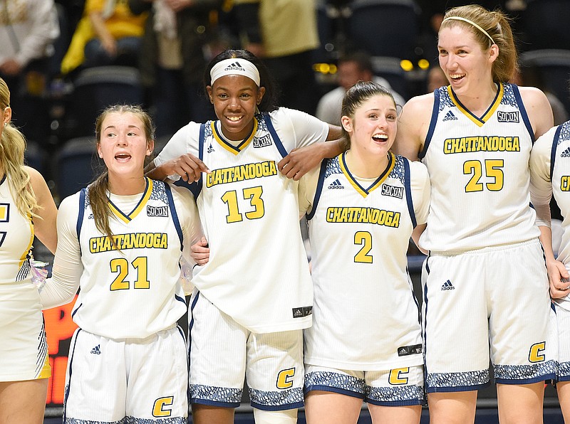 Staff photo by Matt Hamilton / From left, UTC basketball players Addie Grace Porter, Yazz Wazeerud-Din, Brooklyn Crouch and Abbey Cornelius sway as they sing the alma mater after Saturday's 78-70 overtime win against Mercer at McKenzie Arena.