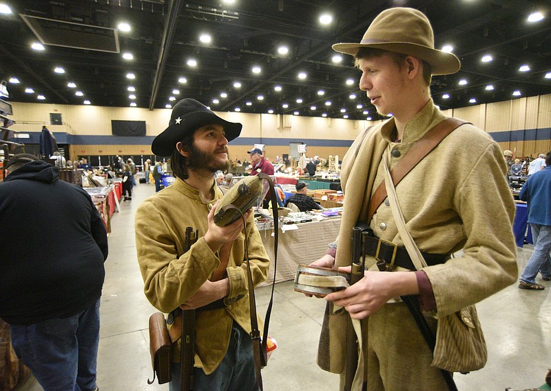 Staff File Photo by Matt Hamilton / Jared Byles, left, and Jonathan Staddon, reenactors with the 65th Georgia Company F, talk about the differences between Union and Confederate canteens on Jan. 30, 2022, at the Dalton Convention Center. The venue will host the return of the Chickamauga Civil War Show Feb. 4-5.
