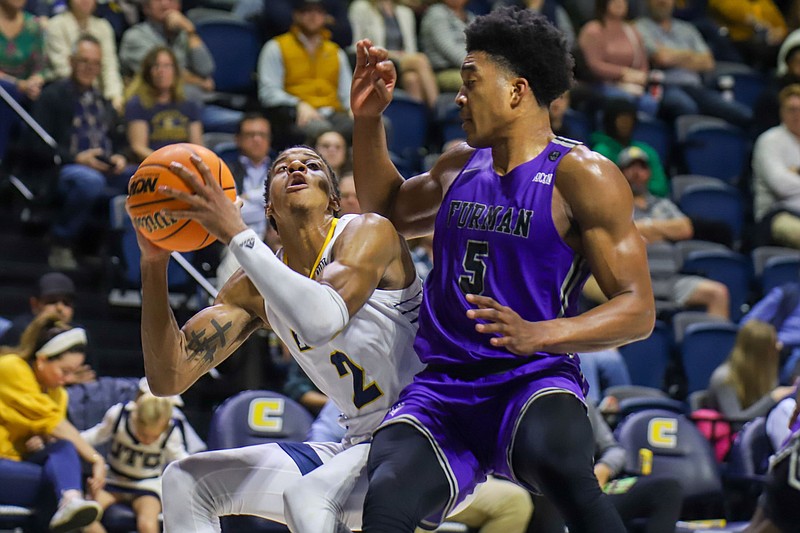 Staff photo by Olivia Ross / UTC's Jamaal Walker shoots as Furman's Marcus Foster defends during Wednesday night's game at McKenzie Arena. In a rematch of last year's SoCon tournament final won by UTC, Furman beat the host Mocs 77-69 in the first of two scheduled regular-season meetings.