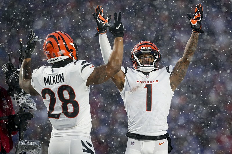 AP photo by Joshua Bessex / Cincinnati Bengals wide receiver Ja'Marr Chase (1) and running back Joe Mixon motion for a touchdown during the third quarter of Sunday's playoff victory against the Buffalo Bills in Orchard Park, N.Y. The Bengals rolled to a 27-10 win and will travel again next weekend to face the Kansas City Chiefs in a rematch of last year's AFC title game won by Cincinnati.