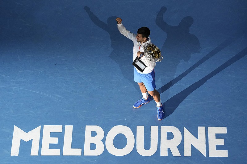 AP photo by NG Han Guan / Novak Djokovic acknowledges the crowd at Rod Laver Arena as he holds his trophy after beating Stefanos Tsitsipas, 6-3, 7-6 (4), 7-6 (5), to win the Australian Open on Sunday in Melbourne. Djokovic added to his record with a 10th men's singles title at the tournament, and he caught up to rival Rafael Nadal for the all-time lead in Grand Slam men's singles championships with 22 overall.