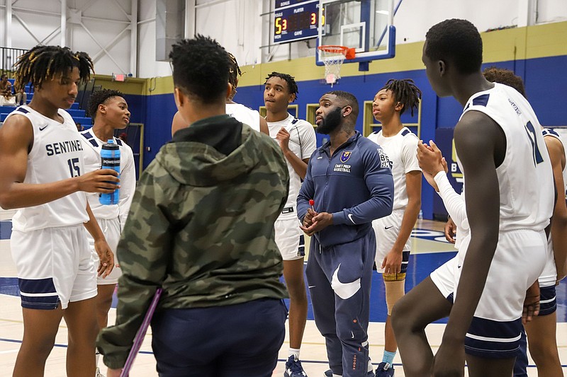 Staff photo by Olivia Ross  / Chattanooga Prep basketball coach Christoffer Collins, center right, speaks with the Sentinels during a timeout in a home game against Sale Creek on Jan. 31.