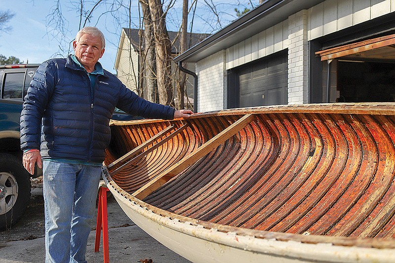 Staff photo by Olivia Ross / BG Smith, Tennessee Valley Canoe Club board director, stands with an antique canoe that he is helping restore to raise money for the paddling club.