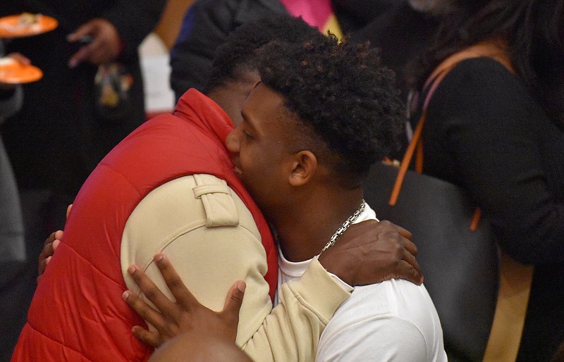 Staff photo by Patrick MacCoon / Baylor baseball and football star Caleb Hampton, right, who will move on to play both sports for Stanford University after his senior year wraps up this spring, gets a hug during the Red Raiders' national signing day celebration Wednesday evening.