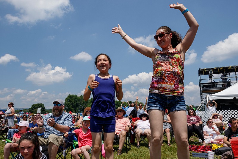 Staff photo / Leah Howard, right, and Kira Ford dance as The Young Escape performs during the JFest Christian music festival at its new location at the Tennessee Riverpark on May 18, 2019. After outgrowing its Camp Jordan venue, the annual festival moved to the larger area along the Tennessee River.